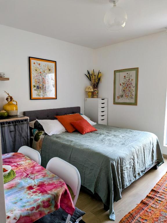 une chambre avec un lit et une table avec des chaises dans l'établissement Havre de paix, à Coulaines