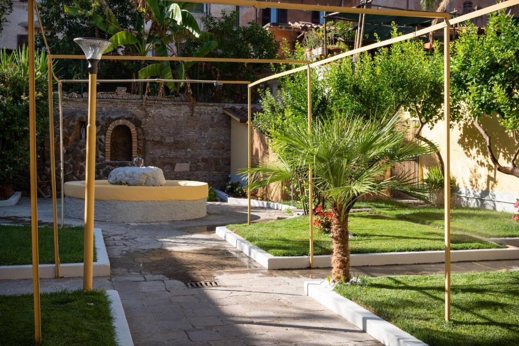 a courtyard with a fountain and a palm tree at Residenza Leone XIII in Rome