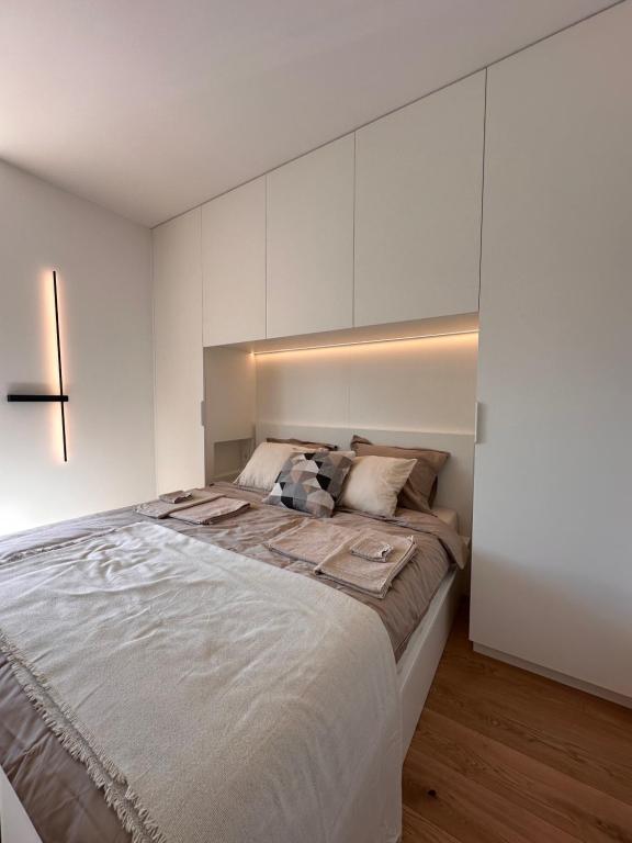 a bedroom with a large bed with white cabinets at Algirdo Sunlight Studio in Vilnius