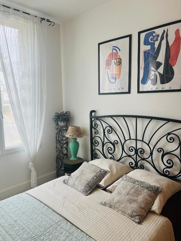 a bedroom with a bed with two pillows on it at Le nid des Petits à 15 min de Bordeaux in Sainte-Eulalie