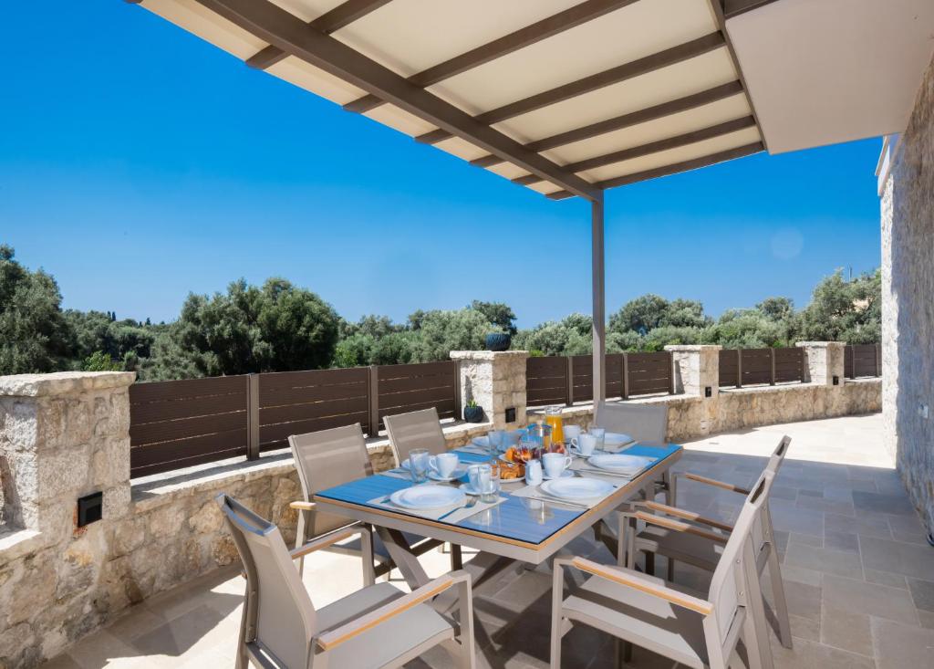 a patio with a table and chairs on a roof at G&S House in Tsoukalades