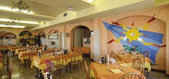 um restaurante com mesas e cadeiras e uma grande sala com em Hotel Ristorante da Toni em Codevigo