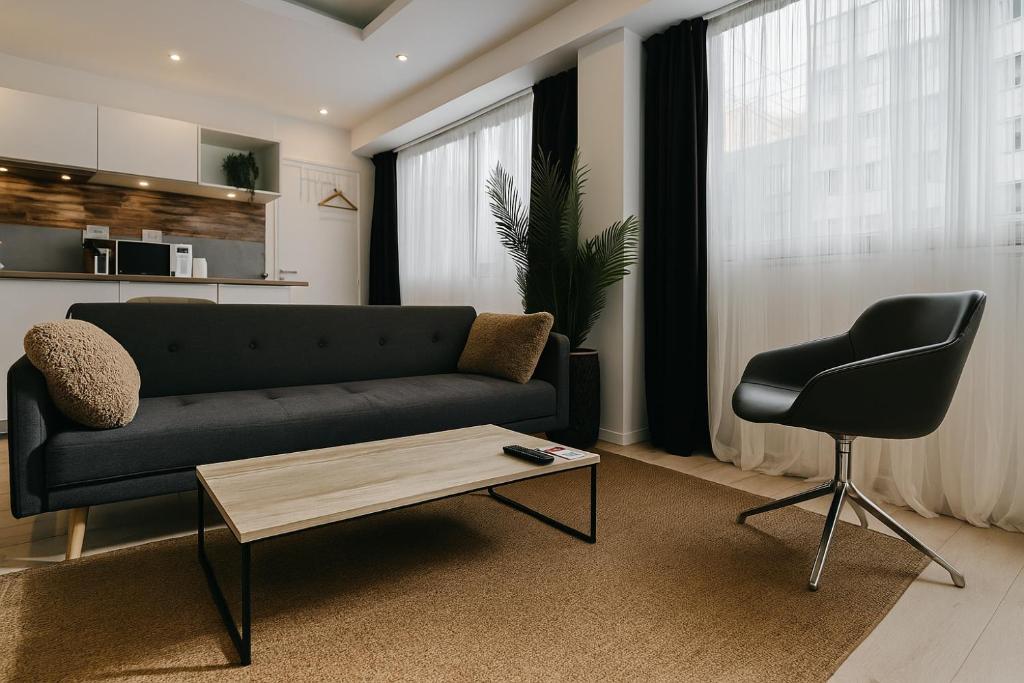 un salon avec un canapé, une table et une chaise dans l'établissement ☆Loft 35m2 Lyon 6 Ménage inclus/pas de check out☆, à Lyon