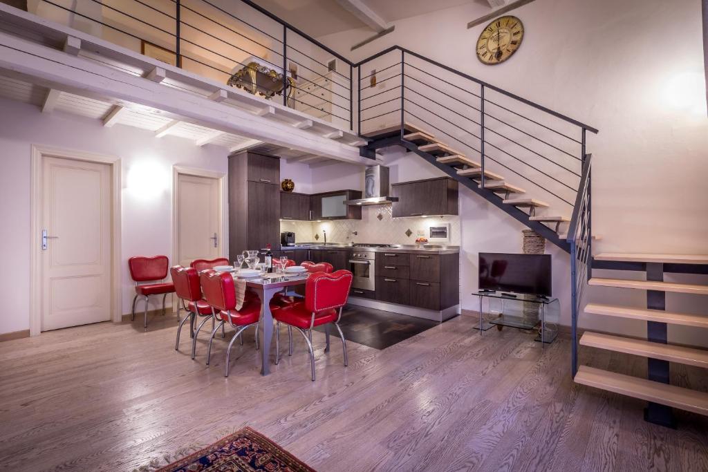 a kitchen and dining room with a table and red chairs at Bandinelli Apartment in Florence