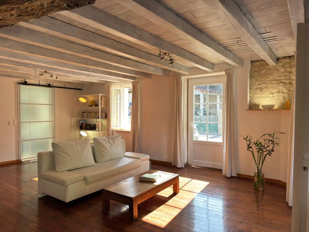 a living room with a couch and a coffee table at Maison Zen 2 chambres - Touverac in Touvérac