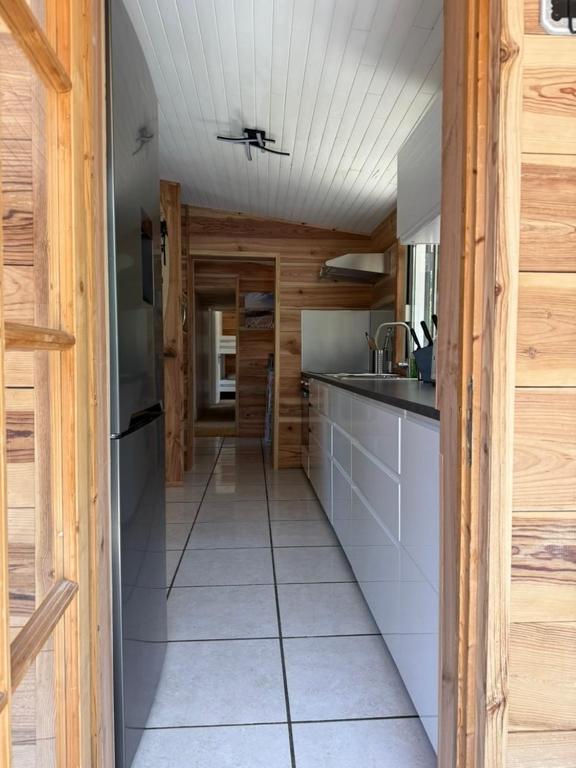 a kitchen with wooden walls and a counter top at La Maison de la forêt et son jaccuzy in Biscarrosse