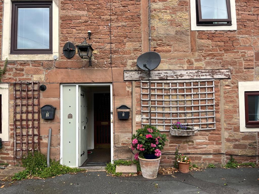 a brick building with a door and a flower pot at Stay Still Indian Court in Dalston