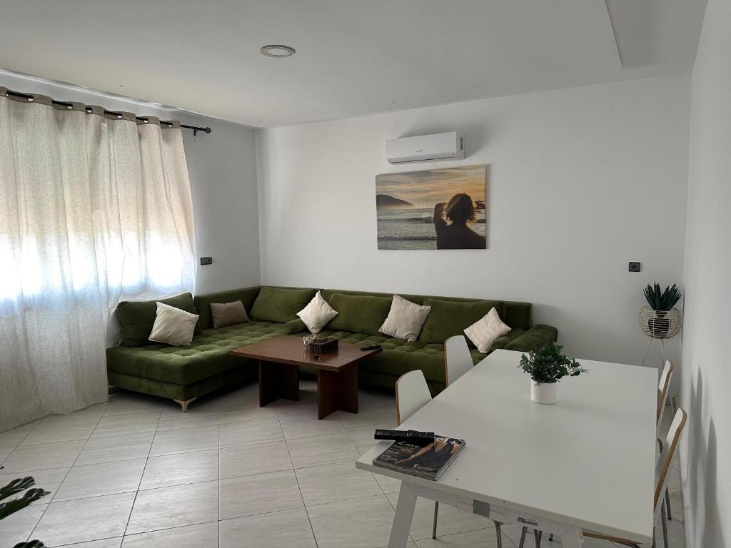a living room with a green couch and a table at Appartement Bleu Azur, Saïdia Plage in Saidia 