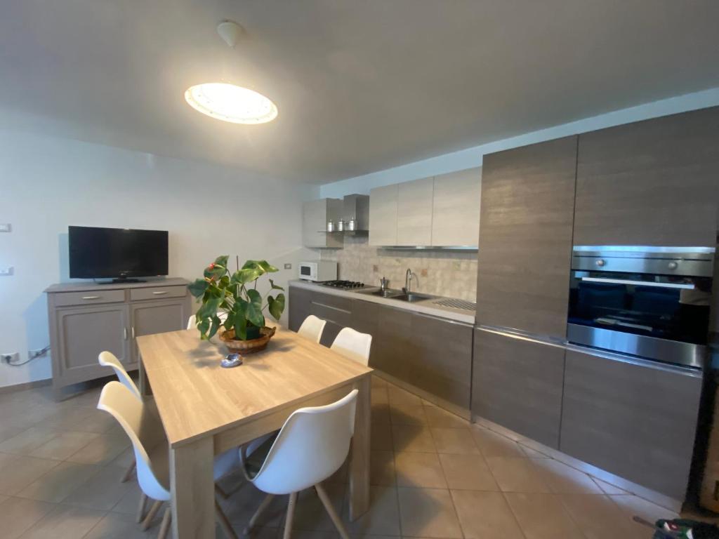a kitchen with a wooden table and white chairs at Dai nonni in Aosta