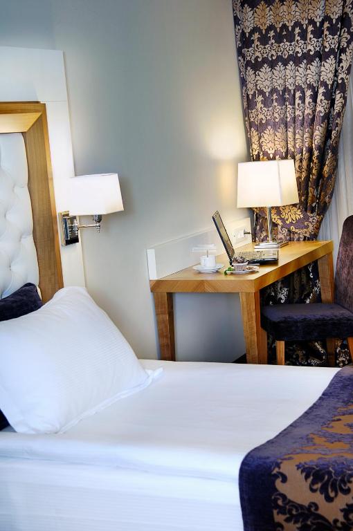 A bed or beds in a room at Tugcu Hotel Select