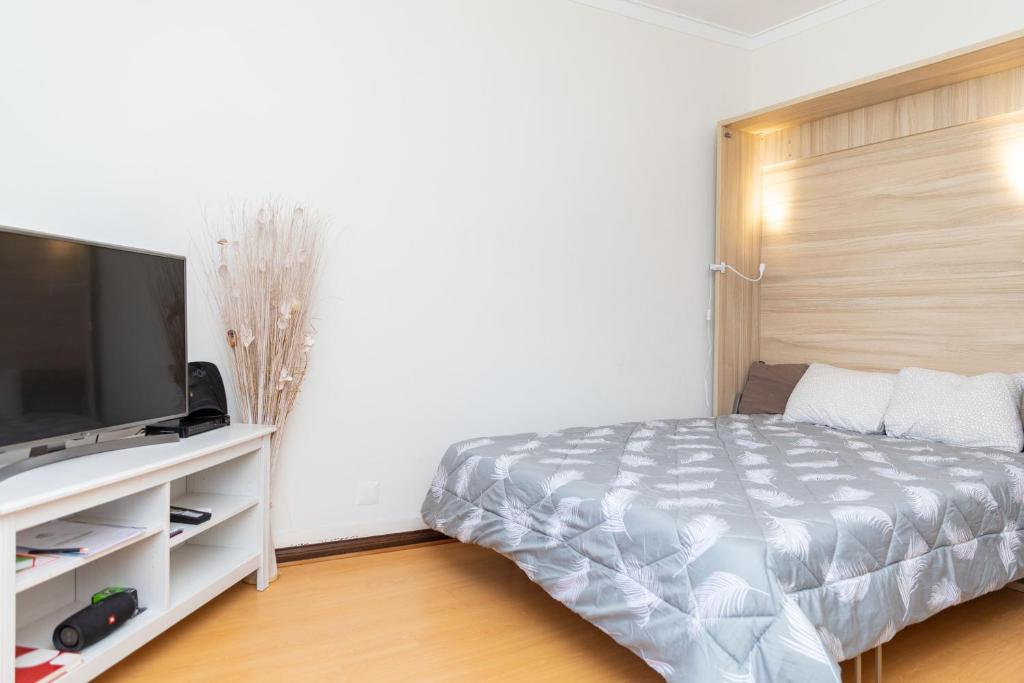 a bedroom with a bed and a flat screen tv at Travessa in Lisbon