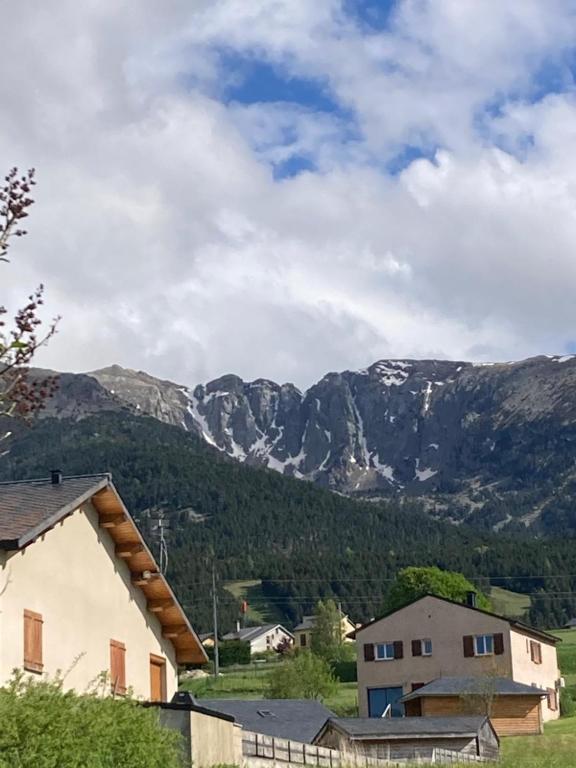 a view of a mountain range with a house and mountains at Le refuge cerdan in Saint-Pierre-dels-Forcats
