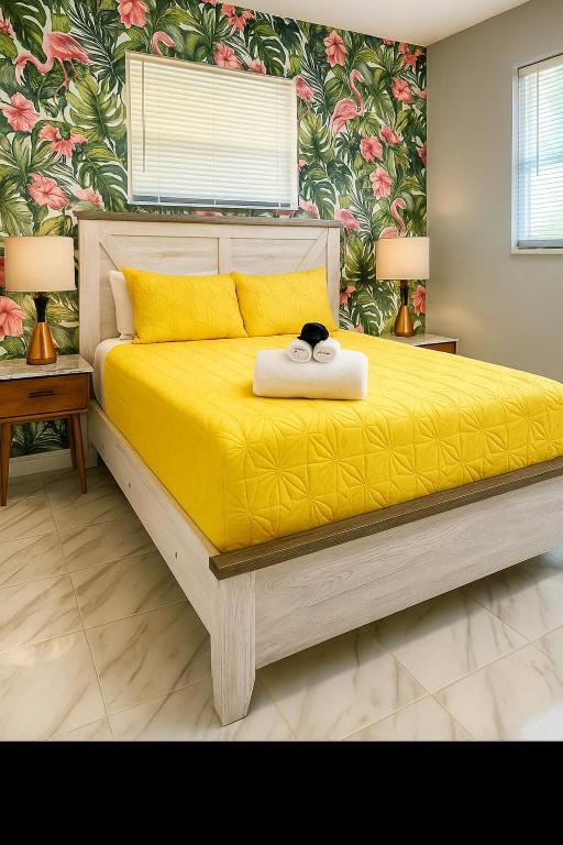 a bedroom with a yellow bed with a cat sitting on it at Charming 1BR Canal Front Retreat in Naples
