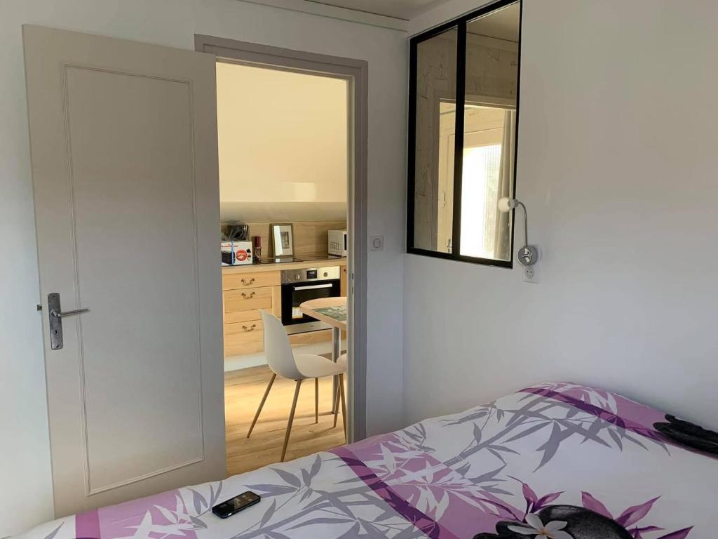 ein Schlafzimmer mit Bett und eine Küche mit Tisch in der Unterkunft Bristol Manor N20 terrasse cuisine et chambre in Néris-les-Bains