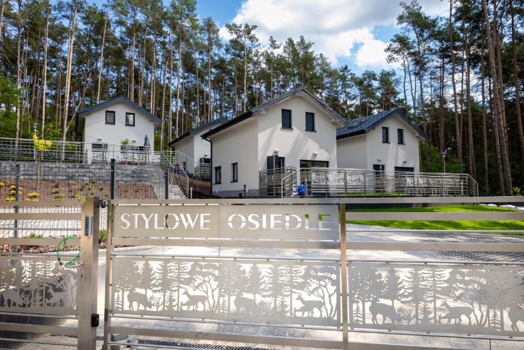 a couple of white houses with trees in the background at Stylowe Osiedle Wieleń - domy wakacyjne in Wielen Zaobrzanski