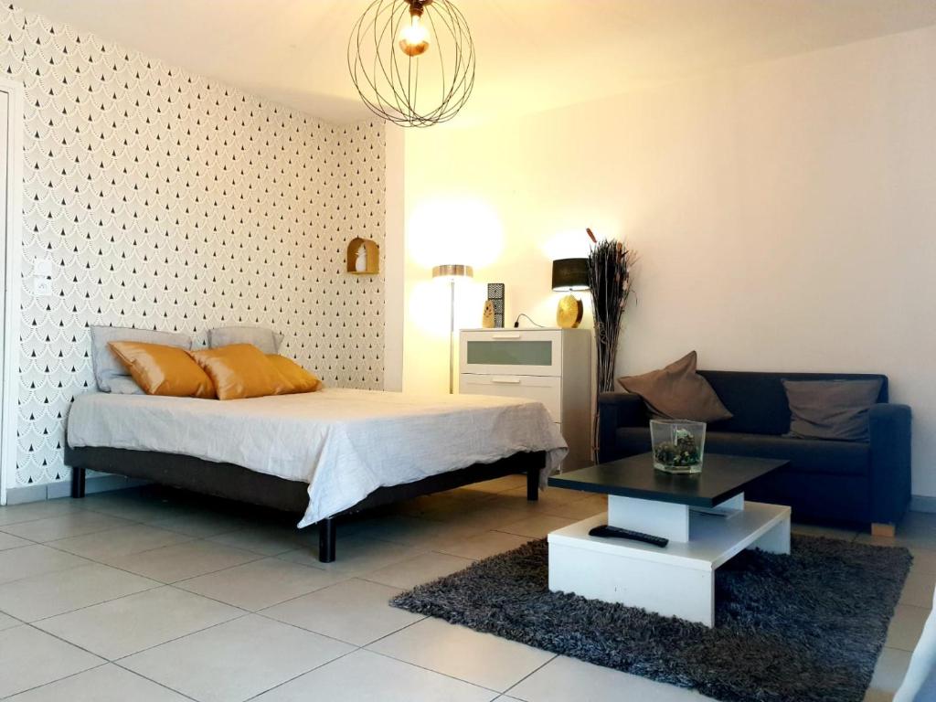 a bedroom with a bed and a couch at Le Contemporain - Wifi - Proche centre ville in Lyon
