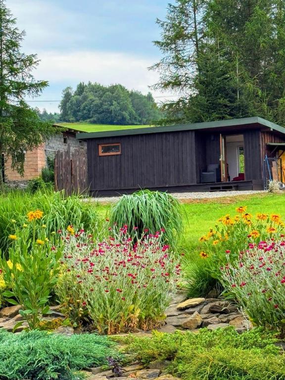 a garden with flowers in front of a building at Beautiful 1 bedroom village house among fields 