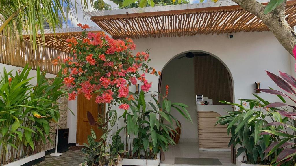 金巴兰Baliem Resort Jimbaran的花卉和植物的建筑物入口