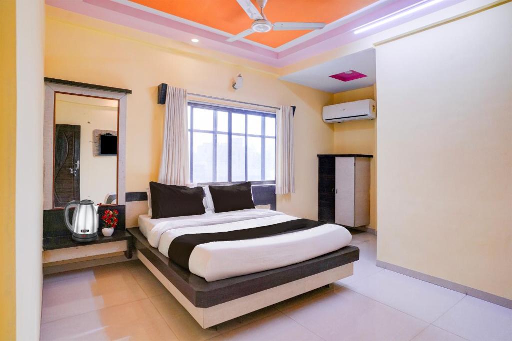 a bedroom with a bed and a large window at Hotel O Datta Nagar Formerly Baba Sai in Shirdi