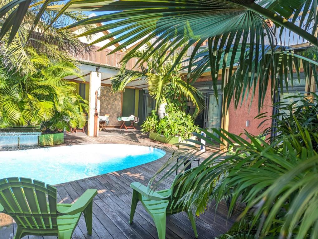 a courtyard with a pool and chairs and a house at La Villa du Patio Parenthèse familiale Piscine 4 in Saint-Pierre