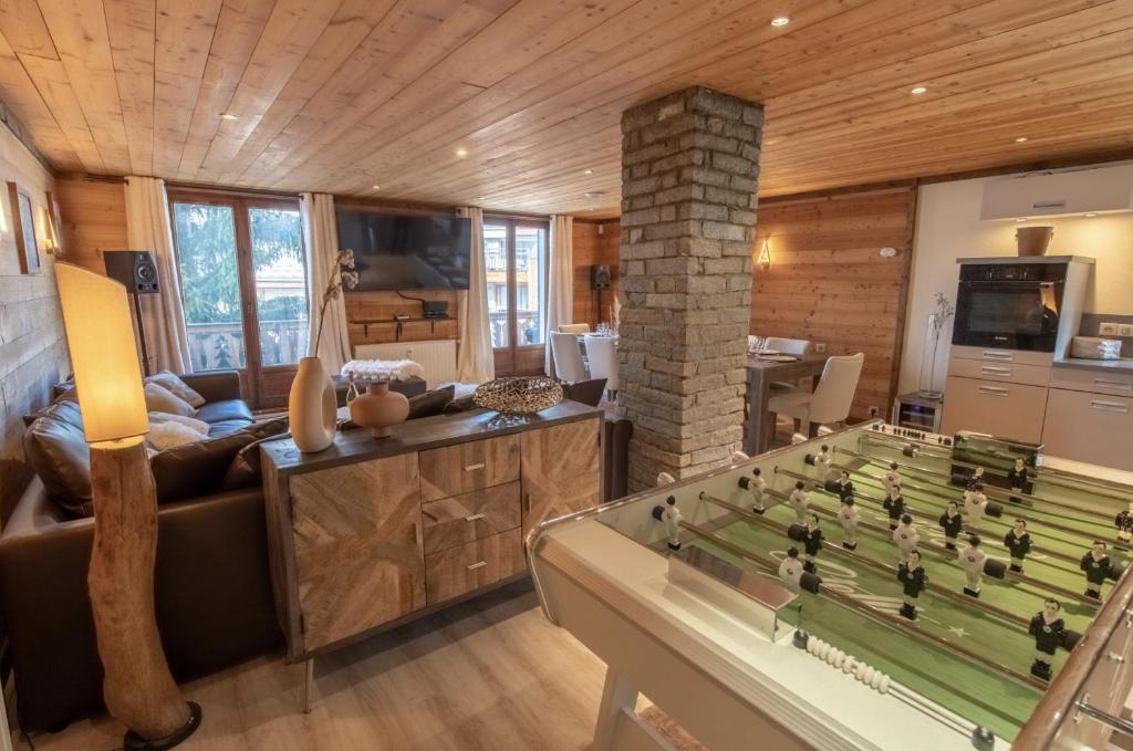 a living room with a foosball table at Catered chalet ideal location centre of Alpe d'Huez - 4 en-suite bedrooms - sauna - private home cinema - 10 people in L'Alpe-d'Huez