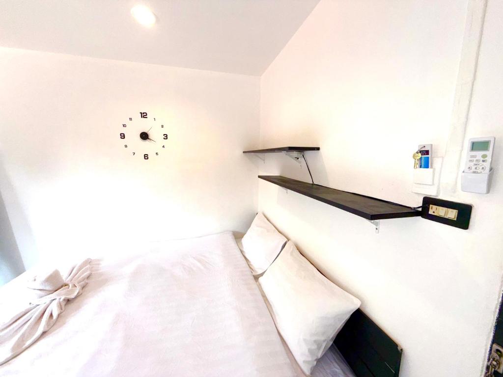 een slaapkamer met een bed en een klok aan de muur bij Patong Canal Villa 305 in Patong Beach