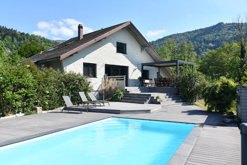 a house with a swimming pool in front of a house at LA PARENTHESE in Saint-Amarin