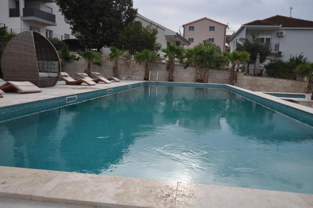 a large swimming pool with lounge chairs in front of a building at Villa Solaria in Seget Vranjica
