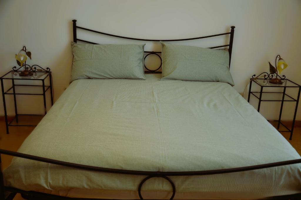 a bed in a room with two end tables at Casa Mila in Marina di Carrara