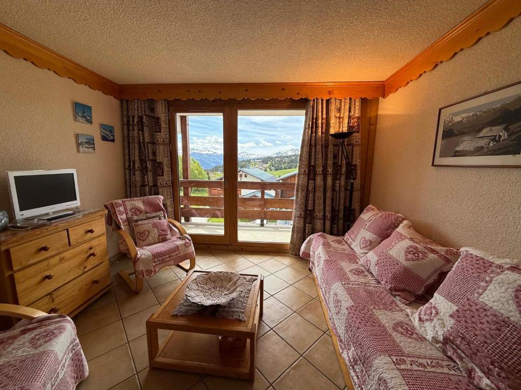 un salon avec un canapé et une télévision dans l'établissement Studio Cabine avec Balcon Sud, 4 Couchages, Equipé, Vue Pistes - FR-1-293-178, aux Saisies