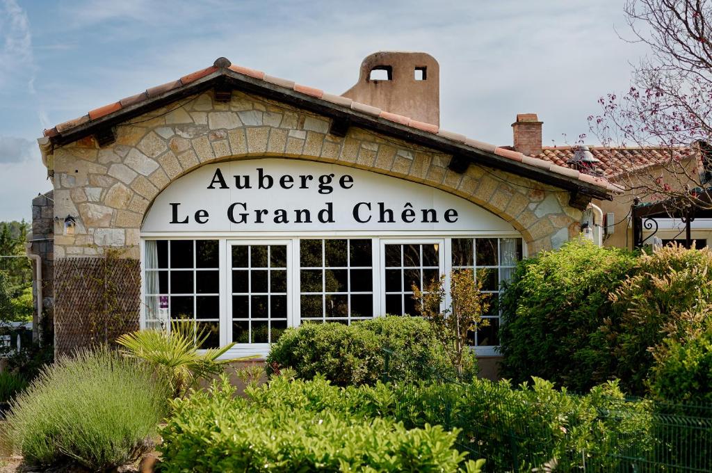 シヤン・ラ・カスカードにあるAuberge du Grand Chêneの観客の大きい機会を読む看板を持つ建物
