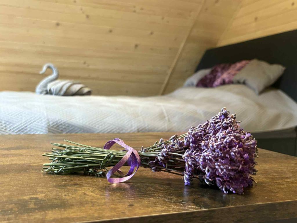 a bunch of lavender on a table next to a bed at Agroturystyka Lawendowa Dolinka Domki Beskid Niski in Chyrowa