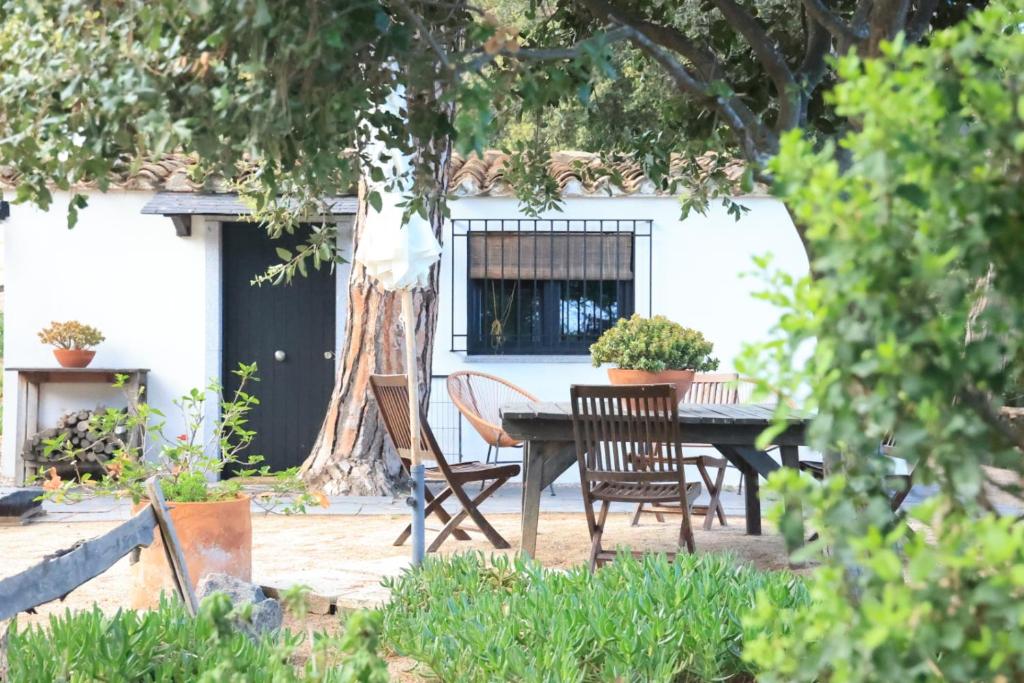 a table and chairs in a yard with a tree at La Casita - Boutique Retreat Barcelona Coast Sea View in Sant Andreu de Llavaneres