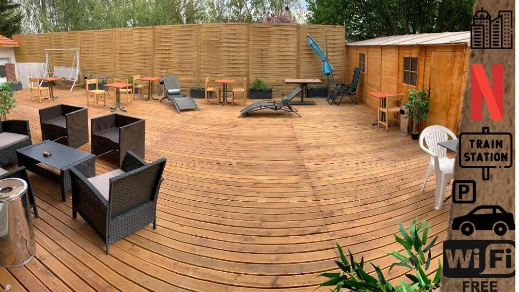 a large wooden deck with tables and chairs on it at Suite 2Chambres salle de bain privés toilettes Terrasse Parking 30 min de Paris in Corbeil-Essonnes