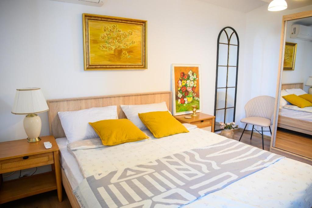 una camera da letto con un letto grande con cuscini gialli di Pipera Studio Apartment a Voluntari