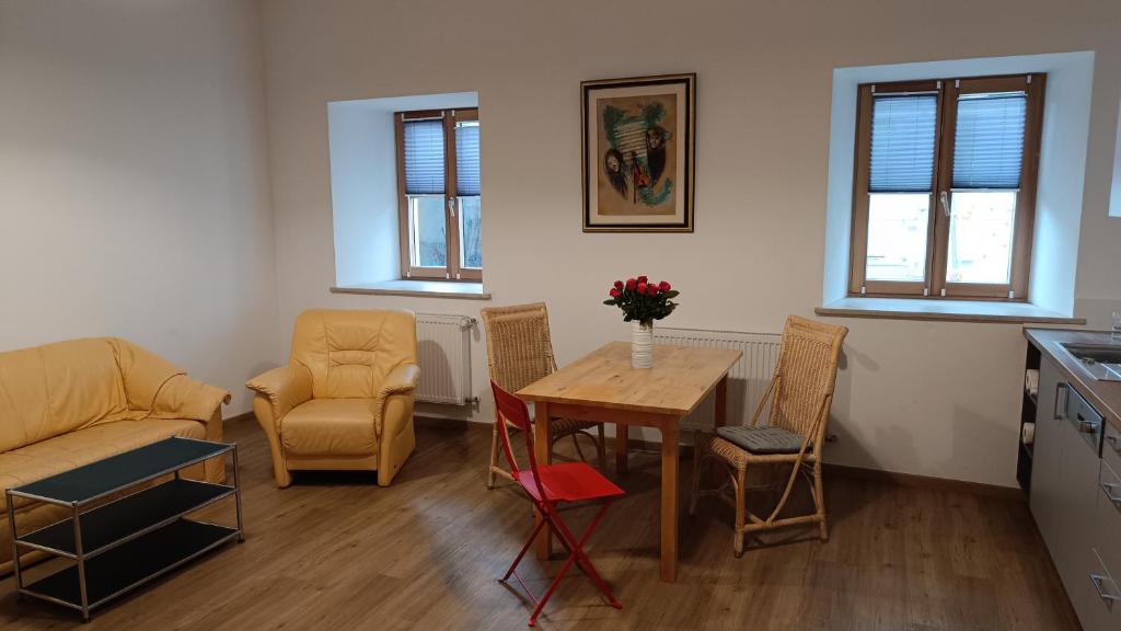 Una sala de estar con una mesa y sillas y un sofá. en Ferienwohnungen zur POST 1, en Breitenbrunn