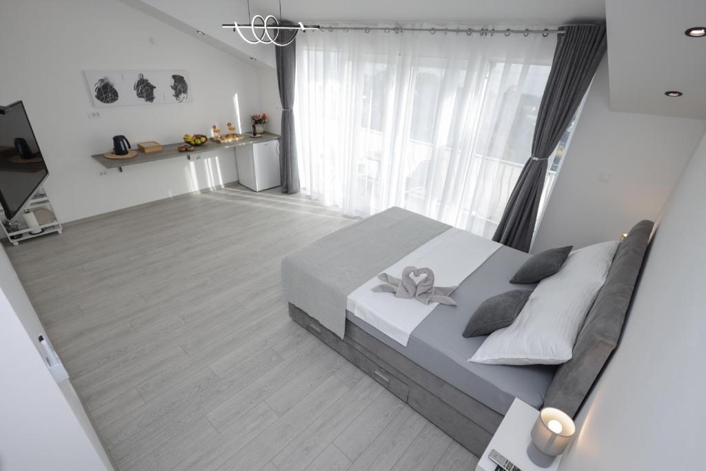 ein Schlafzimmer mit einem Bett und einem großen Fenster in der Unterkunft Studio Andrea in Dubrovnik