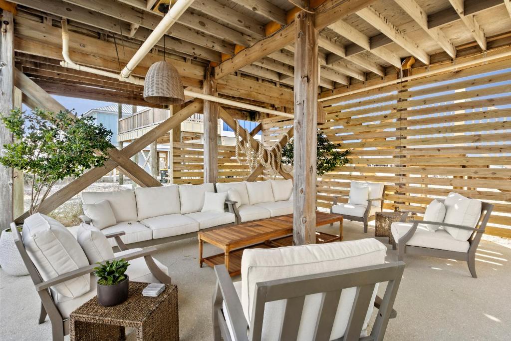 a living room with white furniture and wooden ceilings at The Morgan in Gulf Shores