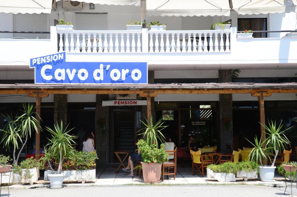 a restaurant with a sign on the front of a building at Cavo D' Oro in Nea Moudania