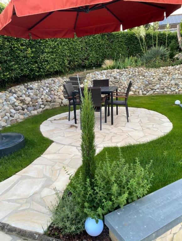 a patio with a table and chairs and an umbrella at Casa Tandri am Rebenweg in Bermatingen