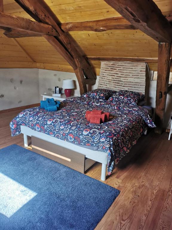a bedroom with a bed and a blue rug at Au cordonnier in Troncens