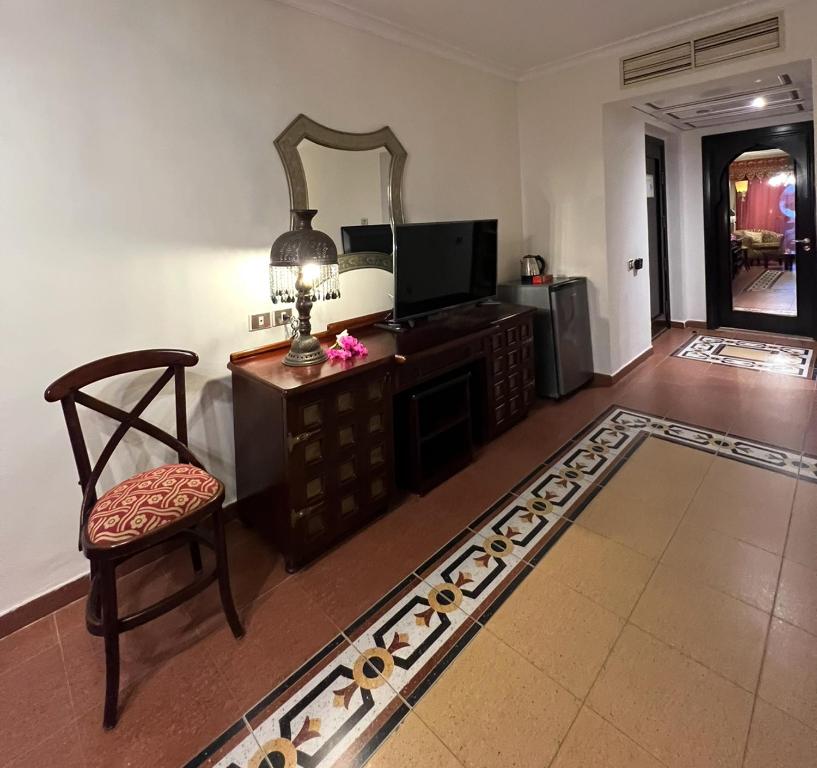 ein Wohnzimmer mit einem Stuhl und einem Spiegel in der Unterkunft Domina Coral Bay Private Studios - Harem - Blocco 60 in Sharm El Sheikh