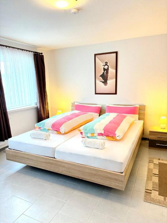 a bedroom with a large bed with colorful pillows at Cosy Holiday Nest in Marienhafe in Marienhafe