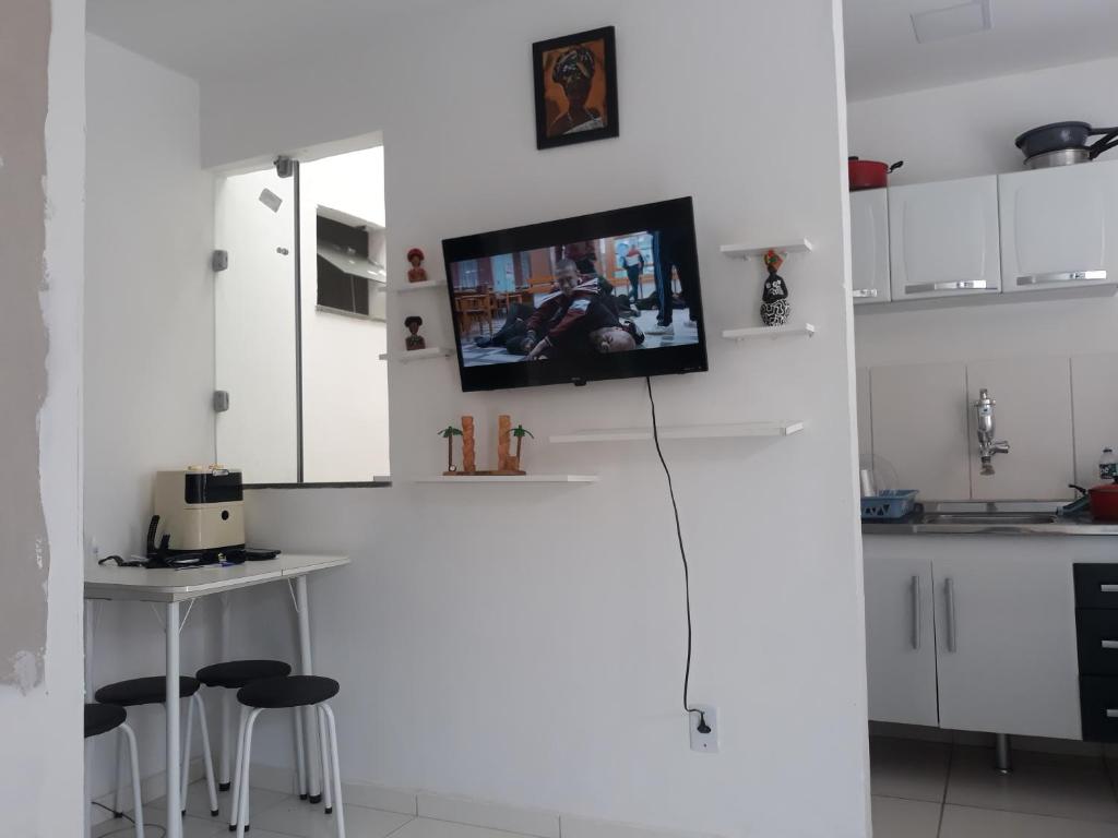 una cucina con un frigorifero bianco con un tavolo e degli sgabelli di Studio a Coroa Vermelha