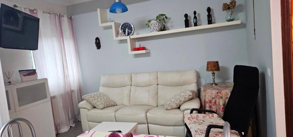 a living room with a white couch and a table at LIENCRES, céntrico, PLANTA BAJA in Liencres