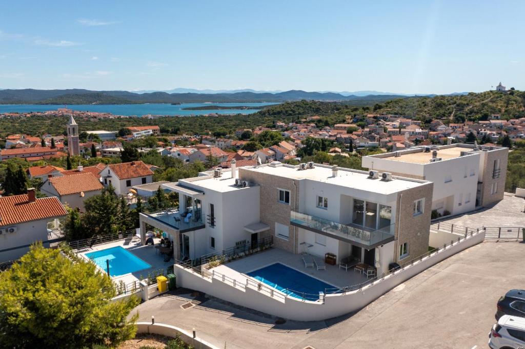 an aerial view of a house with a swimming pool at Alma Mare - Modern Apartment with Soul & View in Murter