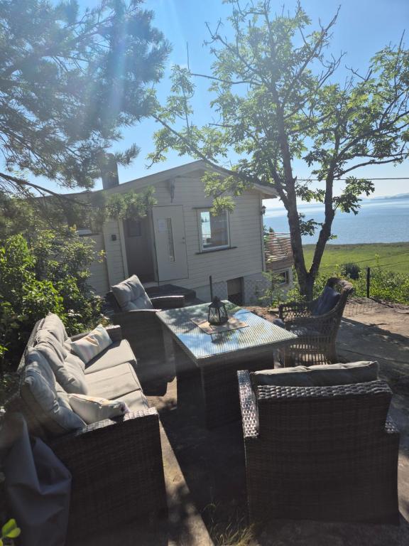 Un patio con mesa y sillas y una casa. en Utsikten Bjerkøya, en Holmestrand