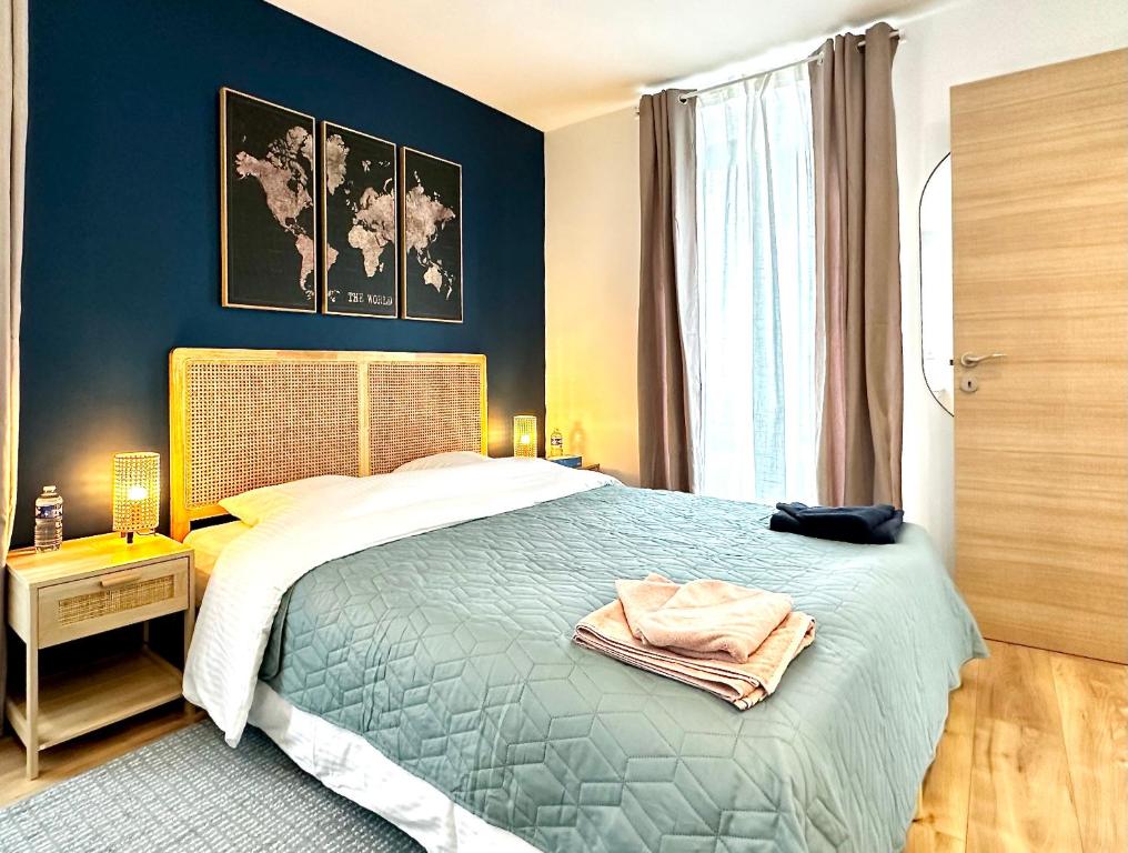 a bedroom with a bed with a blue wall at Airbnb à Paris-Bois de Vincennes in Saint-Maurice