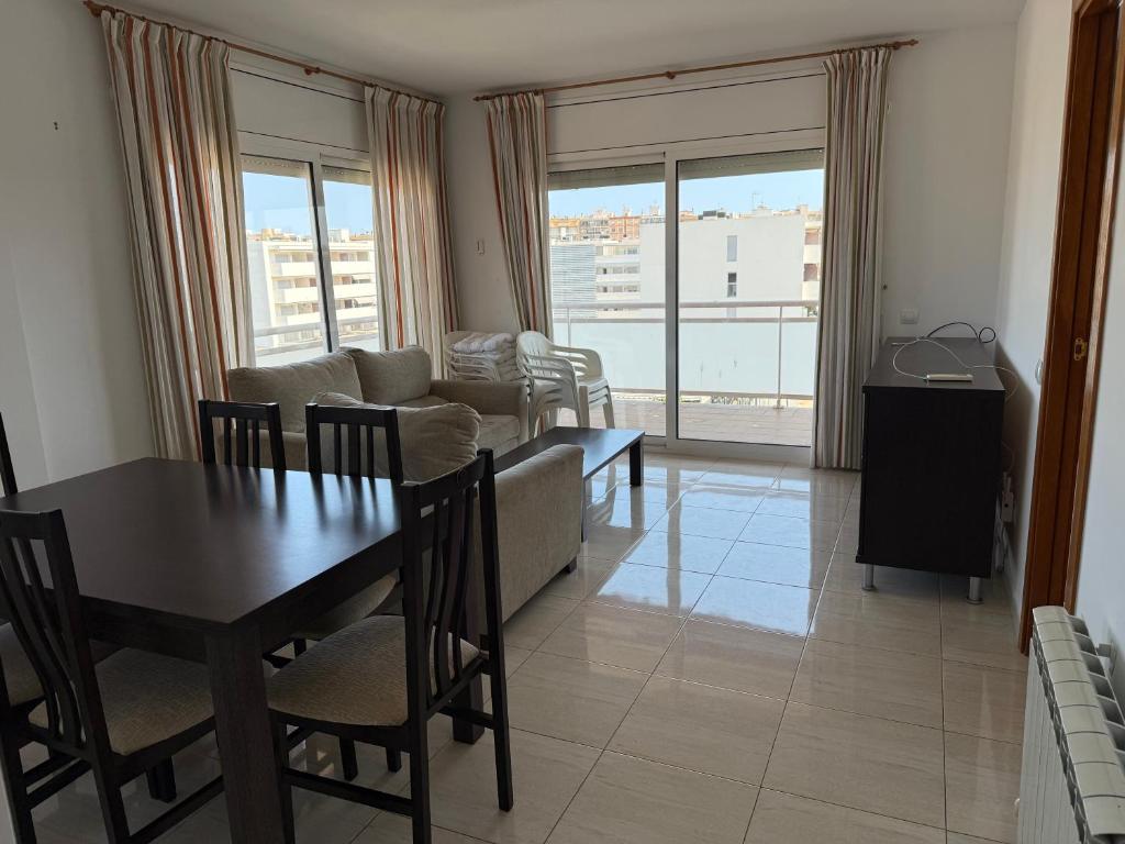 ein Wohnzimmer mit Tisch und Couch in der Unterkunft Atico 3 dormitorios Sant Antoni a 400m de la playa in Sant Antoni de Calonge