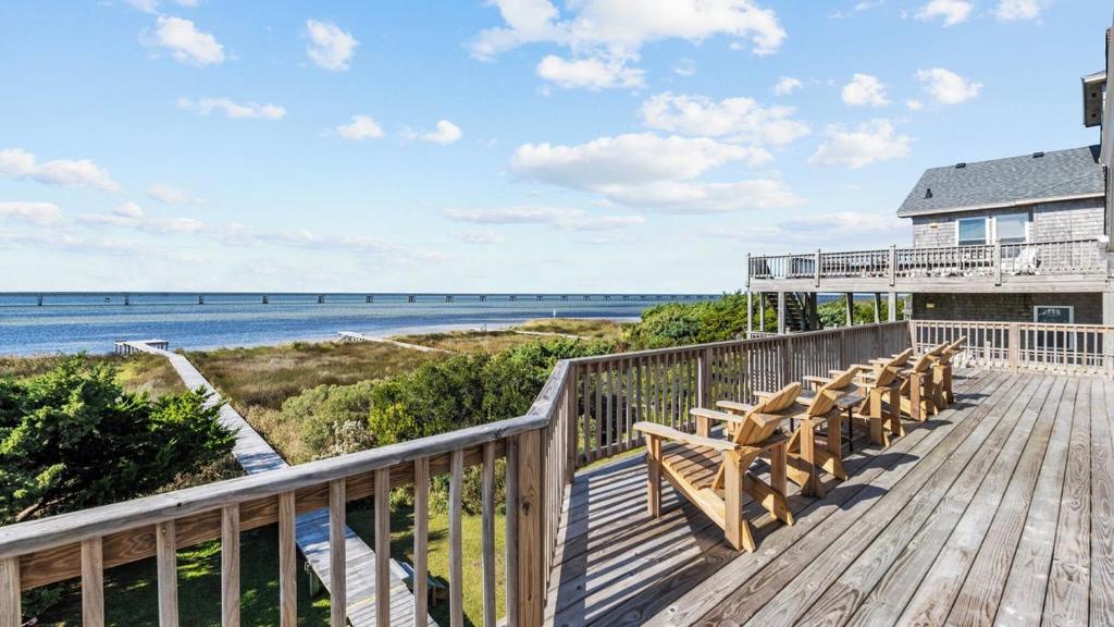 une terrasse avec des chaises et l'océan en arrière-plan dans l'établissement Luxury Waterfront Villa, à Rodanthe